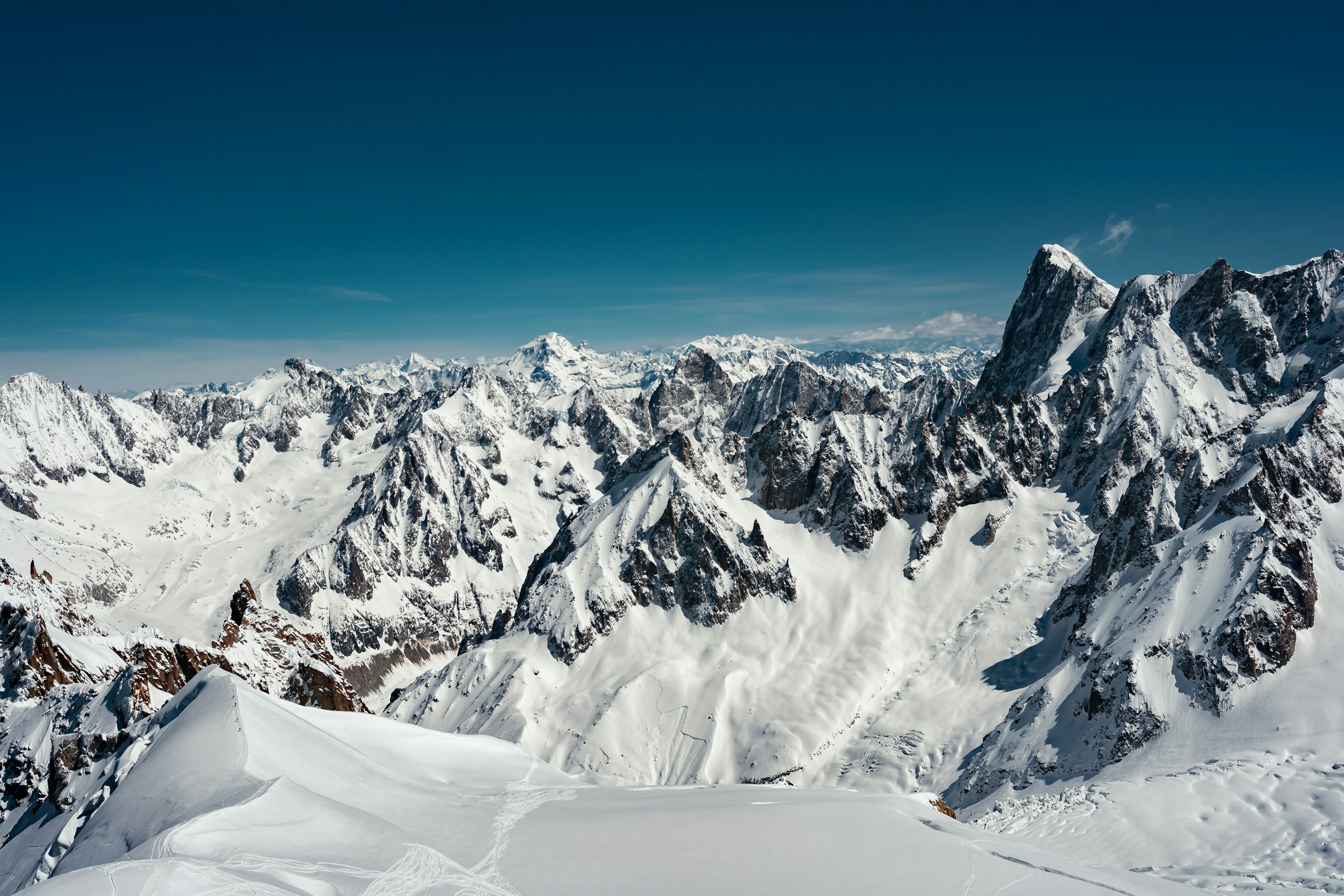 Snow-covered peaks of the Chamonix mountain region beneath a clear blue sky